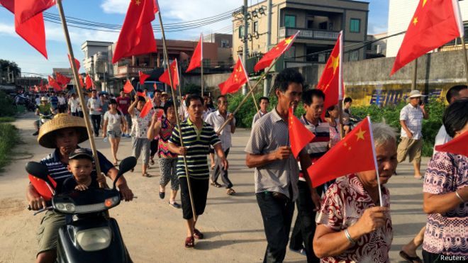 乌坎村民在黄昏前聚集在一起，他们举着红旗，喊要求释放村委主任林祖恋的口号。