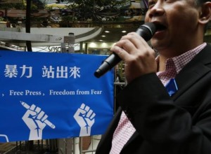 A newspaper columnist urges passersby to support stabbed former Ming Pao chief editor Kevin Lau in Hong Kong February 28, 2014.   REUTERS/Bobby Yip