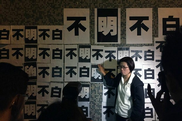 Staff at Hong Kong's Ming Pao newspaper stick protest slogans to the walls