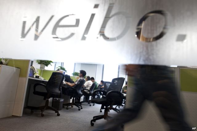 Employees work at their desks at a Sina Weibo office in Beijing