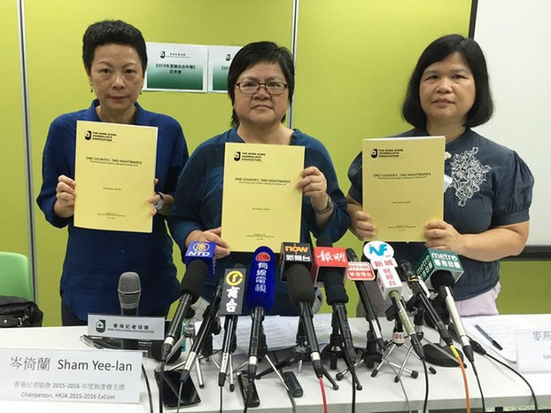 Members of the Hong Kong Journalists' Association display their annual report, July 3, 2016