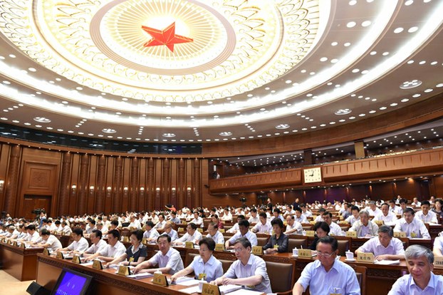 Members of China's National People's Congress Standing Committee vote during their closing meeting in Beijing