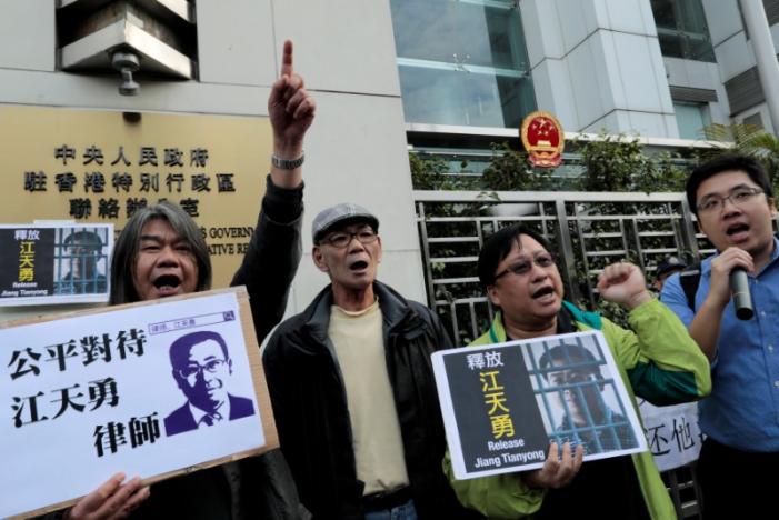 Pro-democracy demonstrators hold up portraits of Chinese disbarred lawyer Jiang Tianyong, demanding his release, during a demonstration outside the Chinese liaison office in Hong Kong, China December 23, 2016. REUTERS/Tyrone Siu