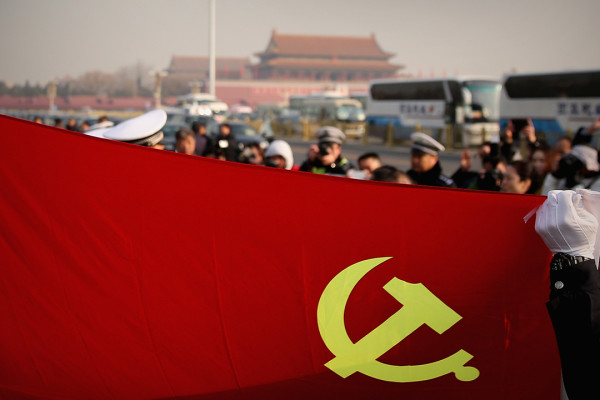 BEIJING, CHINA - MARCH 05: Policemen holding the flag of China's Communist Party pose for photos during the opening session of the National People's Congress at the Tiananmen Square on March 5, 2015 in Beijing, China. The government work report presented the main targets of economic and social development, a projected 2015 GDP growth of about 7 percent; and consumer prices rising about 3 percent. (Photo by Feng Li/Getty Images)