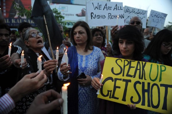 Activists of Human Rights Commission of Pakistan (HRCP) hold candles and placards as they shout slogans during a protest against the killing of Pakistani lawyer Rashid Rehman in Islamabad on May 8, 2014. Lawyers in the central Pakistani city of Multan went on strike to mourn a colleague who was shot dead for defending a university lecturer accused of blasphemy. Gunmen stormed the office of lawyer Rashid Rehman on May 7 evening and started firing indiscriminately, killing him and injuring two others. AFP PHOTO/Aamir QURESHI / AFP / AAMIR QURESHI