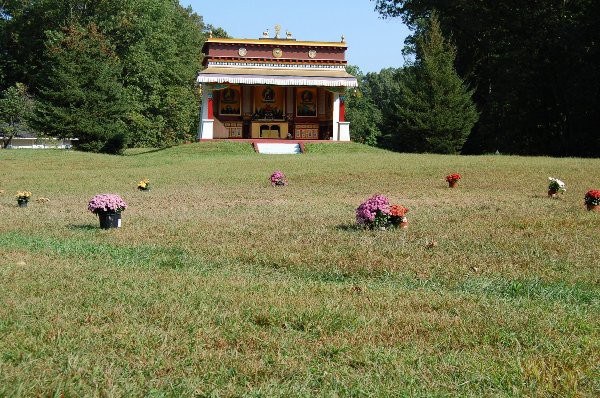 在达赖喇嘛讲经座的前面,鲜花环绕着火葬塔泽仁波切法体的地方