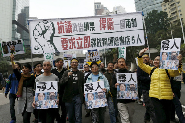 Demonstrators hold up portraits of five missing staff members of a publishing house and a bookstore during a protest over the disappearance of booksellers, in Hong Kong, China January 10, 2016. The banner reads, "Against political kidnapping. Safeguarding One Country, Two Systems. Demanding the immediate release of the five people from Causeway Bay Books." REUTERS/Tyrone Siu - RTX21PV7