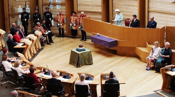 Queen Elizabeth II speaks as Ken Macintosh, Presiding Officer of the Scottish Parliament, top 2nd right, and her husband, the Duke of Edinburgh, top right, listen, during the opening of the fifth session of the Scottish Parliament in Edinburgh, Saturday July 2, 2016. The monarch used her address to refer to "increasingly complex and demanding" times. The opening ceremony was held just over a week after the UK voted to leave the EU - but Scotland's vote to stay prompted fresh fears over the future of the Union, with a second independence referendum now a real possibility. (Andrew Milligan/PA via AP)