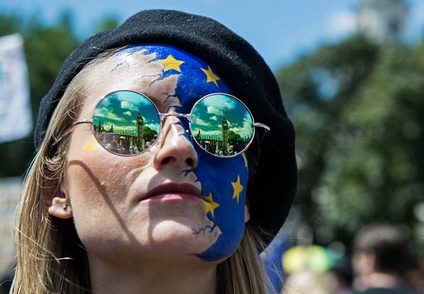 The Houses of Parliament are reflected in a woman's glasses as thousands of protesters gather in Parliament Square after taking part in a March  for Europe, through the centre of London on July 2, 2016, to protest against Britain's vote to leave the EU, which has plunged the government into political turmoil and left the country deeply polarised. Protesters from a variety of movements march from Park Lane to Parliament Square to show solidarity with those looking to create a more positive, inclusive kinder Britain in Europe. / AFP PHOTO / CHRIS J RATCLIFFE