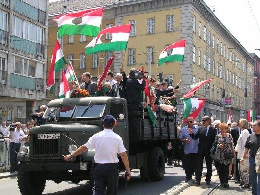 布达佩斯的学生和市民高举着挖掉共产党纹章的国旗游行