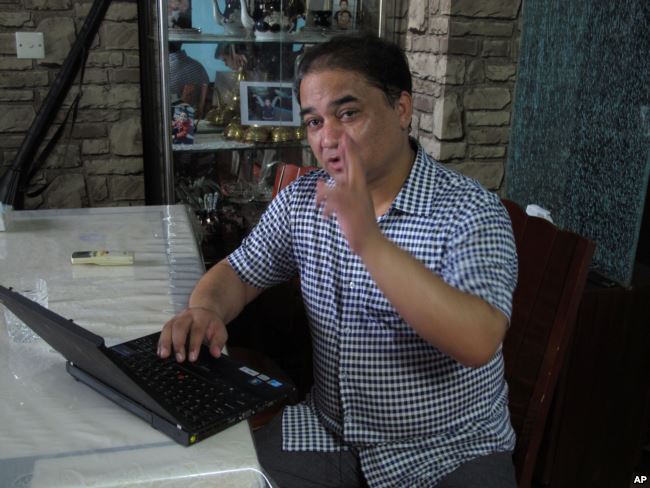 Outspoken Uighur scholar and advocate Ilham Tohti gestures during an interview at his home in Beijing on Friday, July 5, 2013. Tohti criticized the authoritarian Chinese government Friday at a time of heightened sensitivities because of recent unrest, saying its stifling security presence has fanned ethnic discord in his far western homeland. (AP Photo/Gillian Wong)