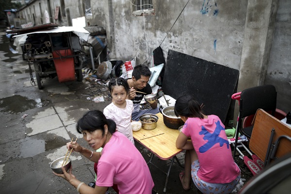 epa06110119 People have lunch outside a rental house located in a demolition area in rural Beijing's Changping district, China, 26 July 2017. Several hundred migrant workers living in their temporary houses have to move out as local government begins to demolish the area following the capital's new urban planning policy. Beijing's new mayor Cai Qi has vowed to cut the city off all the functions unrelated to its status of national capital, in an effort to push the growing population into the surrounding provinces and to tear down wholesale markets and urban villages where the migrants work and live, in an attempt to force lower-income residents out of the city.  EPA/WU HONG