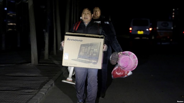 北京的外来务工人员手里提着有限的个人物品被连夜赶出他们在北京通州六环外的住所
