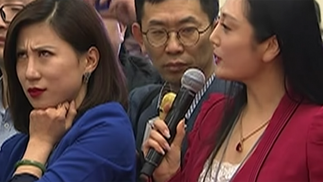 翻白眼事件中的两位女记者，穿蓝衣的是梁相宜，穿红衣的是张慧君。